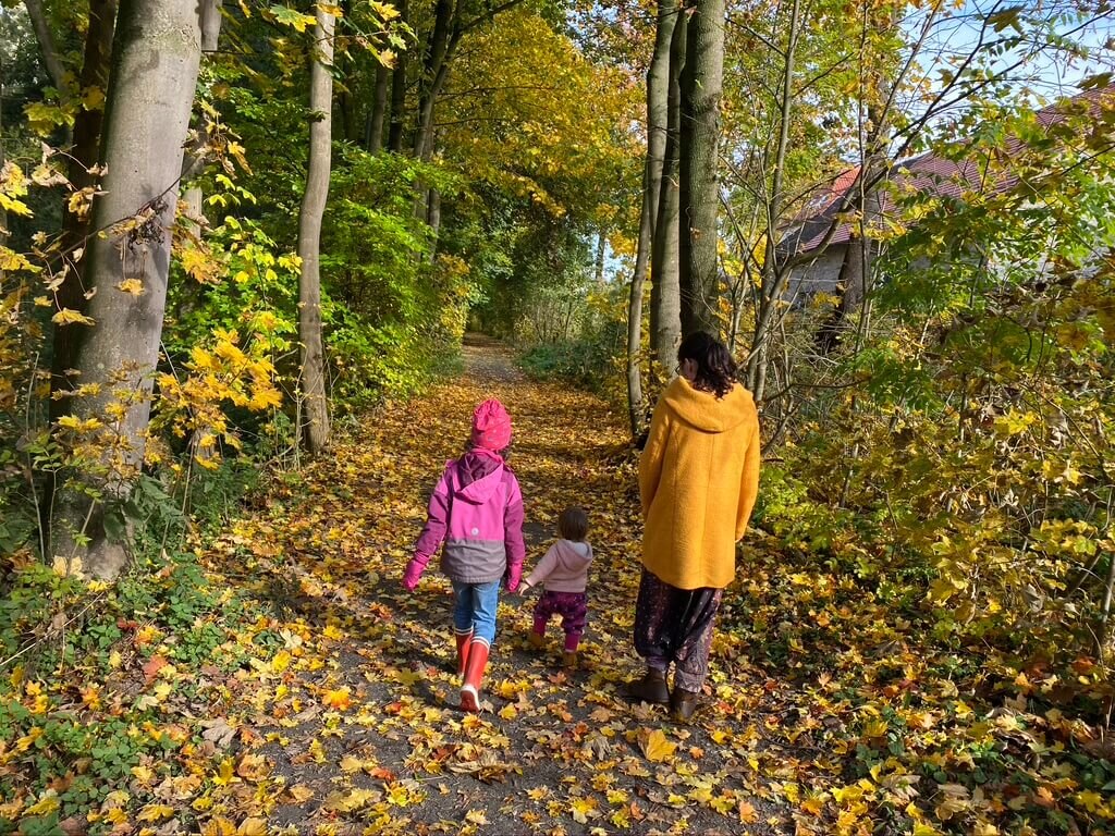 Eine Familie geht gemeinsam einen ruhigen Weg entlang